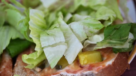 Feinkost-Sandwich-Mit-Gurken,-Salat,-Ketchup,-Veganer-Mayo,-Auf-Vollkornbrot,-Das-Zusammengestellt-Wird