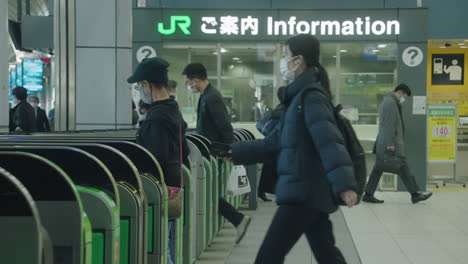 Passengers-And-Ticket-Gates-At-Shinagawa-JR-Station-In-Tokyo---People-Wearing-Masks-During-Pandemic---medium-shot,-slow-motion