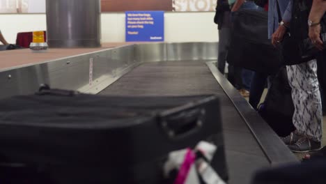 Baggage-goes-down-a-conveyor-and-is-picked-up-by-a-passenger