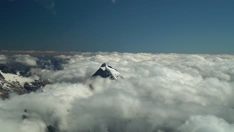 Cámara-Lenta---Monte-Tasman,-Alpes-Del-Sur,-Nueva-Zelanda---Cumbre-Nevada-En-Las-Nubes-Desde-Un-Vuelo-Panorámico-En-Avión
