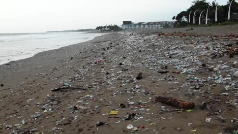 Pull-back-shot-of-a-disgustingly-polluted-beach,-plastic-waste-dumped-in-the-ocean-washed-out-by-the-ocean