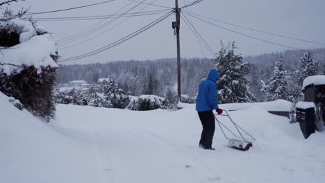 Man-is-removing-snow-from-the-front-of-the-house-with-big-shovel-after-big-snow-storm-in-Norway