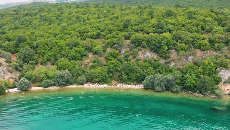 Aerial-truck-shot-from-left-to-right-of-Macedonian-shore-in-Ohrid-Lake,-Pesztani-and-Trpejca