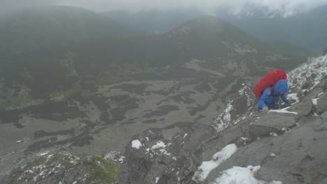 rocky-alpine-peaks,-landscape-of-a-slovakian-tatra-mountains,-handheld-shot-of-a-female-hiker-climbing-a-rocky-peak