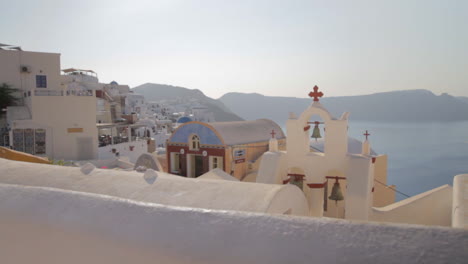 Blick-Auf-Das-Dorf-Oia-Mit-Kykladischer-Architektur-Auf-Santorini,-Mit-Farbenfrohen-Dächern-Und-Der-Majestätischen-Meereslandschaft-Von-Santorini-Im-Hintergrund