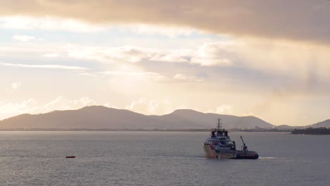 French-tug-ship-maneuvering-near-buoy-at-sunset