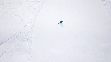 Aerial---Top-view-tracking-shot-of-good-alpine-skier-skiing-down-the-wide-ski-slope-alone