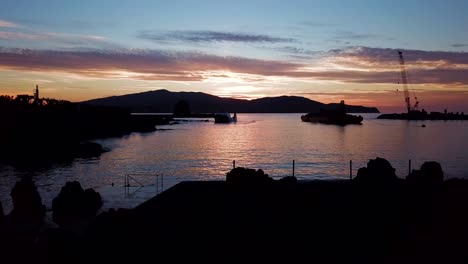 Schiebeaufnahme-Eines-Violetten-Sonnenuntergangs-Im-Hafen-Von-Madalena,-Atemberaubende-Schatten-Der-Küste