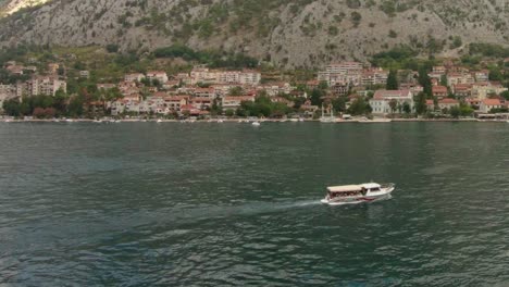 Slow-motion-shot-of-boats-sailing-off-the-coast-of-a-beautiful-mountainous-town-in-Montenegro