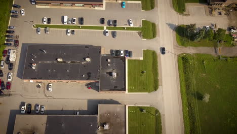 Drone-flying-over-busy-parking-lots-in-a-massive-industrial-complex