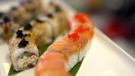 The-close-up-video-of-red-caviar-on-Philadelphia-sushi-rolls-and-cook's-knife