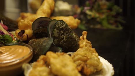 Der-Küchenchef-Bereitet-Das-Gericht-Mit-Neuseeländischen-Grünschalenmuscheln-Auf-Einem-Teller-Mit-Grünem-Salat,-Austern-Und-Soße-Zu---Nahaufnahme