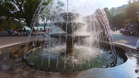 Wunderschöner-Brunnen-In-Hanoi-In-Der-Altstadt-Von-Vietnam,-Gefilmt-Mit-120-Bildern-Pro-Sekunde-In-Einer-Pan-Up-Bewegung-Mit-Vorbeifahrendem-Roller
