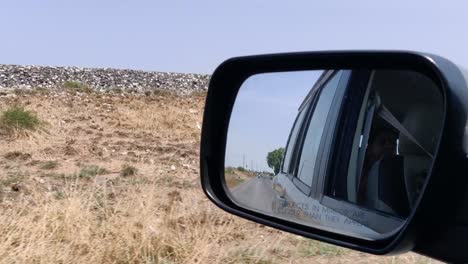 Ein-Blick-Auf-Karges-Land-Aus-Einem-Fahrenden-Auto-Und-Seinem-Seitenspiegel