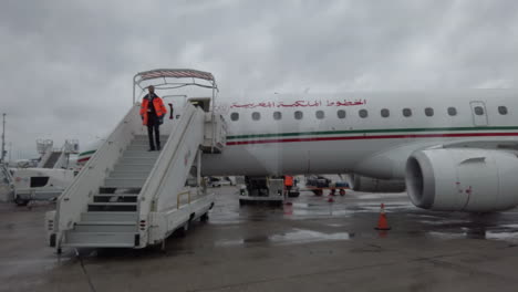 Paris-Orly-airport,-seen-from-a-passenger-shuttle-in-front-of-a-Royal-Air-Maroc-aircraft,-employed-in-uniform-who-descend-the-steps-of-the-platform-to-authorize-boarding