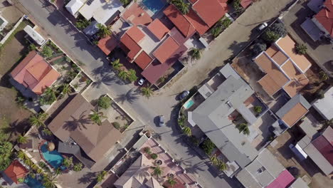 A-car-driving-down-a-residential-street-in-Noord,-Aruba
