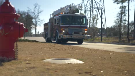 Fire-truck-drives-past-fire-hydrant-with-emergency-lights-on