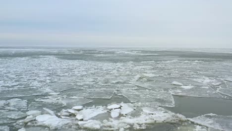 Drone-flying-backwards-over-melting-ice-in-early-spring