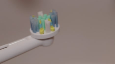 Detail-shot-of-mint-toothpaste-layered-on-an-electric-toothbrush