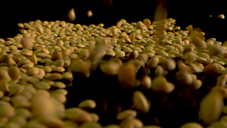 Green-Lentils-Falling-In-Slow-Motion-on-a-black-mirrored-surface