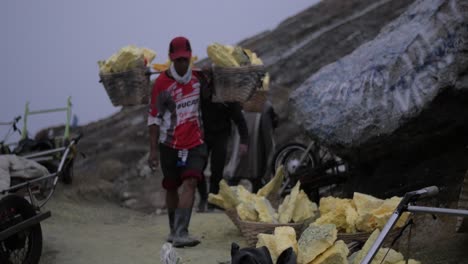 Kawah-Ijen-sulphur-workers-coming-in-the-background-with-a-trailer-full-of-sulphur-in-the-foreground-in-the-early-morning