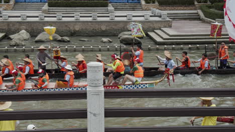 Chinese-people-paddle-and-hit-drums-on-a-dragon-boats-during-dragon-boat-festival-in-downtown-of-Guangzhou,-Guangdong,-China