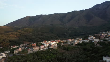 Luftaufnahme-Vom-Traditionellen-Griechischen-Dorf-In-Griechenland-Bei-Sonnenuntergang-Mit-Bergen-Im-Hintergrund