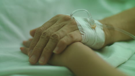 Nahaufnahme-Eines-Alten-Und-Kranken-Patienten,-Der-Mit-Einer-Frau-Händchen-Hält