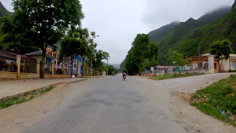 First-person-view-of-a-narrow-winding-rough-road-that-cuts-through-the-mountains-and-valleys-of-northern-Vietnam