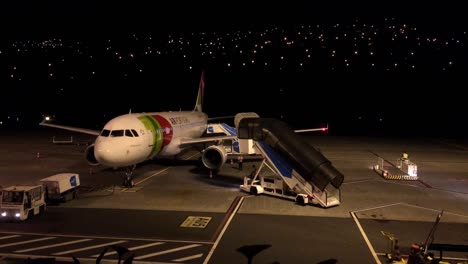 TAP-Night-time-Airport-pos-landing-operations,-assistance-support-airplane-passenger-boarding-bridge-mobile-staircase-air-craft-CR7-International-Airport