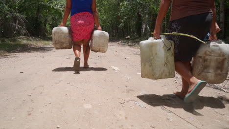 Mujeres-En-Honduras-Cargan-Jarras-De-Agua-Pesada-En-Un-Camino-De-Tierra