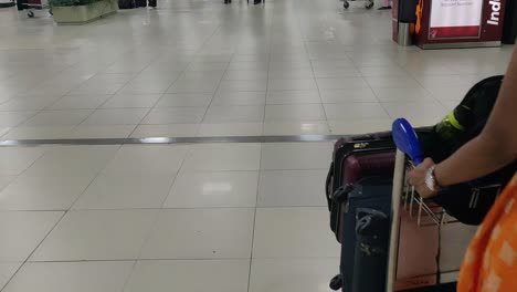 Una-Niña-Que-Lleva-Un-Carrito-Lleno-De-Bolsas-Dentro-Del-Aeropuerto-Internacional-De-Delhi