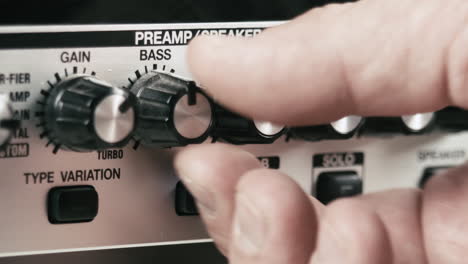 Musician's-hand-sets-up-the-levels-of-a-guitar-preamp-multi-effect,-close-up