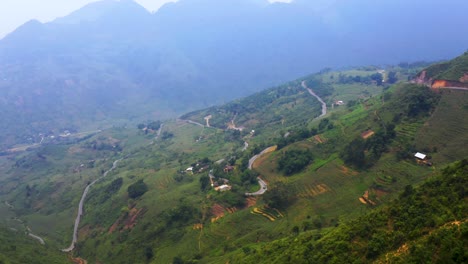 Aerial-dolly-forward-while-tilting-up-over-the-misty-mountains-of-northern-Vietnam