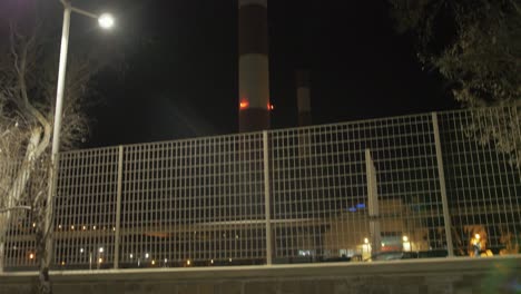 Factory-chimney-red-and-white-pattern-pan-up-shot-at-night-flashing-lights