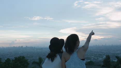 Two-Teenage-Girls-Taking-A-Photo-And-Admiring-The-Scenery-Of-A-City-Sunset