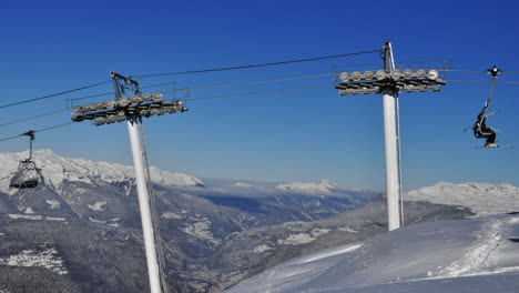 Time-lapse-of-a-chair-lift-in-the-French-Alps-with-a-valley-and-blue-sky-in-the-back-ground-in-winter