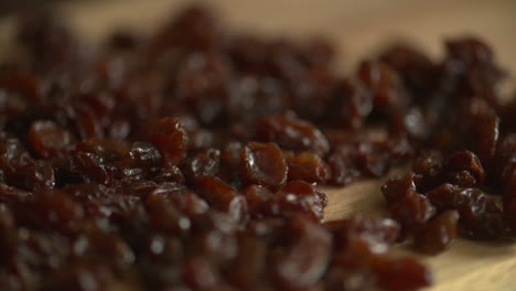 Pan-across-a-bunch-of-delicious-raisins-on-a-wood-cutting-board