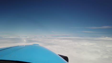 Forward-view-from-cockpit-small-turboprop-airplane-flying-above-clouds