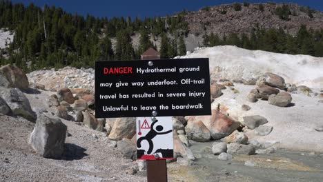 A-DANGER-sign-warning-all-visitors-to-stay-on-the-pedestrian-walkway-at-Bumpass-Hell-hiking-trail-in-Lassen-Volcanic-National-Park,-California