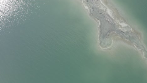 Aerial-rotating-pull-up-top-down-shot-of-salt-shore-estuary-in-the-Dead-Sea-Israel,-drone-shot