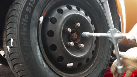 Man-mechanic-screwing-up-wheel-bolts