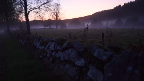 camera-follow-a-stone-wall-in-the-nature-with-a-misty-field-in-the-background
