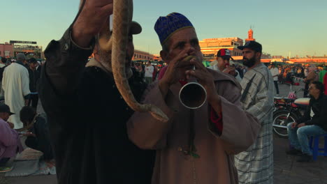 Medium-shot-of-two-snake-charmers-at-Djemaa-el-Fna,-Marrakesh,-Morocco