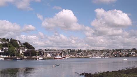 Time-lapse-of-passing-white-clouds-over-blue-sunny-sky-and-river-with-distant-Kinsale,-town-in-Ireland