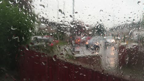 Regen-Fällt-Auf-Das-Fenster-Mit-Verschwommenem-Hintergrund-Des-Stehenden-Verkehrs-Draußen-Auf-Der-Straße