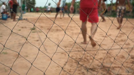 Primer-Plano-Gente-Jugando-Voleibol-Detrás-De-Una-Cerca-De-Metal-De-Cadena