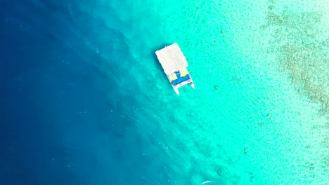 Aéreo,-Pequeño-Barco-Turístico-Navegando-En-El-Agua-De-Mar-Turquesa-Cristalina-Tropical-Sobre-El-Arrecife-De-Coral,-Maldivas
