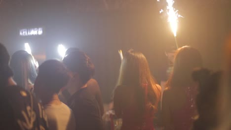 many-young-asian-girls-wave-candles-and-lights-at-club-to-honor-birthday-person