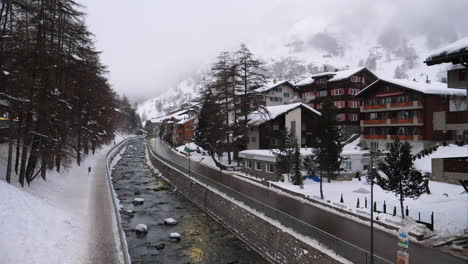 Snow-covered-Zermatt,-Switzerland-with-a-waterway-running-though-it-for-run-off